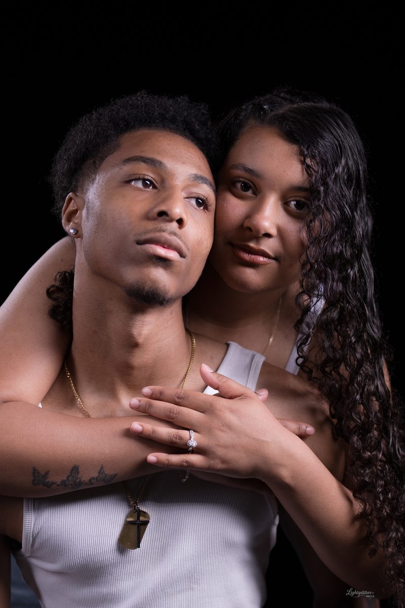 Engagement portrait, her hands and ring resting on his chest