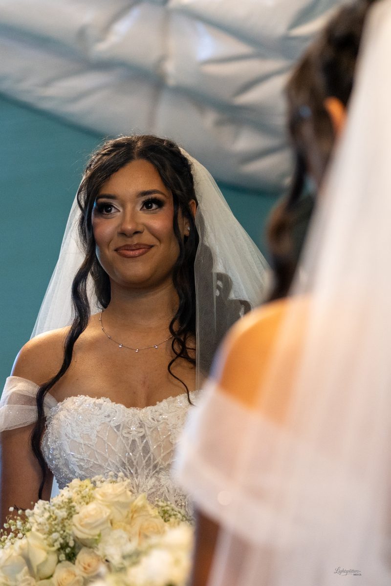 Bride smiling at her reflection while getting ready