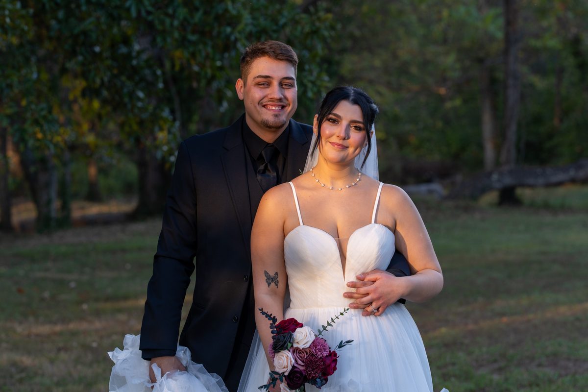 Newlyweds smiling together at golden hour