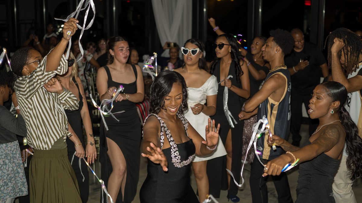 Guests dancing with ribbon wands at the reception